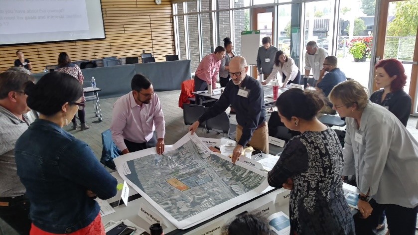 Una imagen del concepto muestra el futuro Kenmore park-and-ride cubierto y posible TOD en inmuebles aledaños. La imagen muestra un edificio de varios pisos, en forma de E, en la esquina de SR 522 y 73rd Avenue NE. Hay otro edificio de varios pisos, en forma de U contiguo al edificio en forma de E, y otro edificio de varios pisos detrás de estos dos. En el extremo de la imagen se ve una representación en gris del futuro estacionamiento cubierto. A este se puede acceder tomando una salida de SR 522, que corre hacia el norte en 73rd Avenue NE. Esta vía da vuelta a la derecha y se dirige hacia el este y luego, hacia el sur hasta el estacionamiento. Asimismo, hay una vía que parece correr del estacionamiento cubierto hacia el sur, a SR 522. A la izquierda del estacionamiento cubierto hay un edificio rectangular de varios pisos. Las estaciones de la Línea Stride S3 se muestran a ambos lados de SR 522; la estación con dirección al oeste está enfrente del estacionamiento cubierto, y la estación con dirección al este, ligeramente al oeste al otro lado de la calle. Los edificios actuales permanecen al centro del lugar, rodeados de nuevos desarrollos.